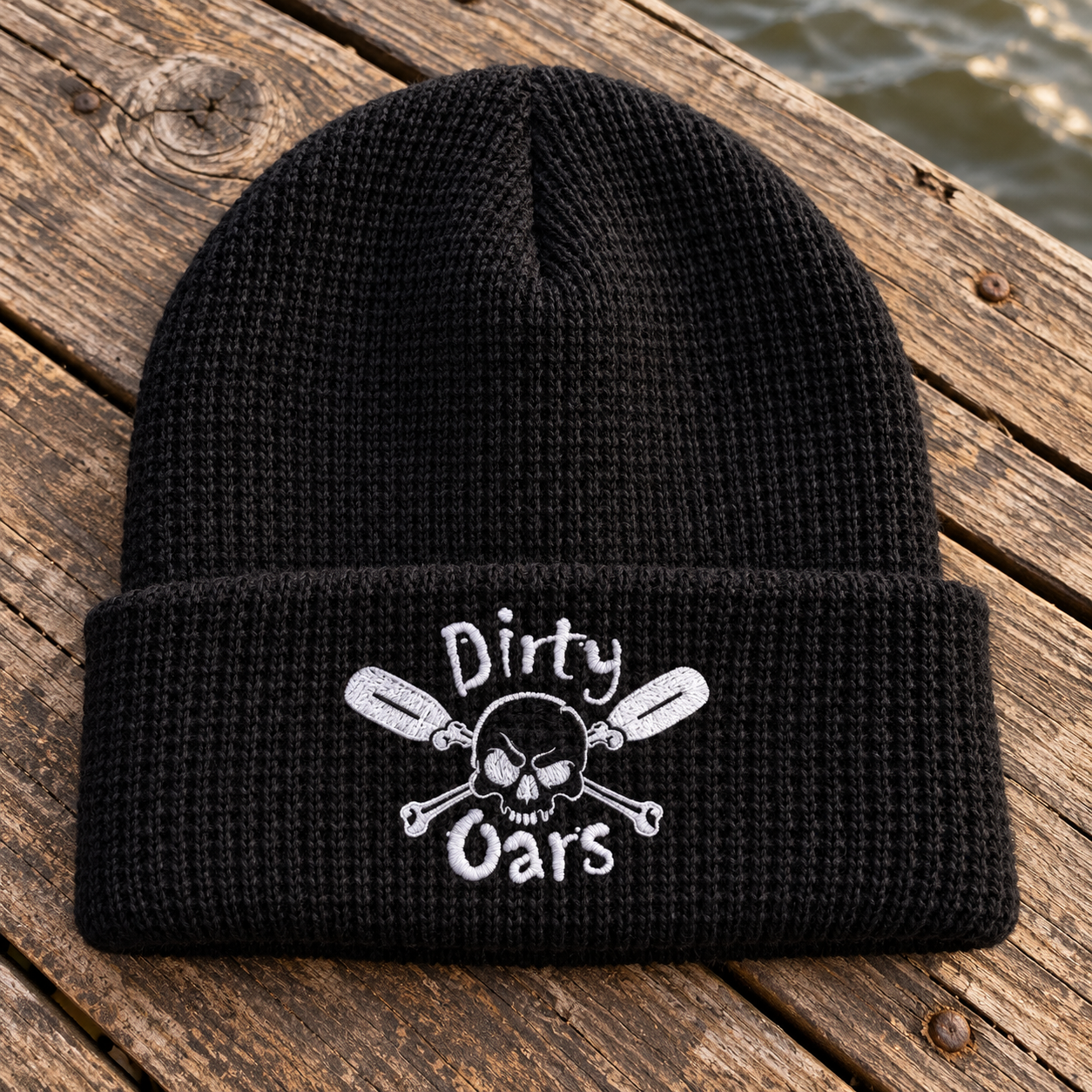 Black Dockside Beanie concept with white Dirty Oars embroidery on weathered dock planks